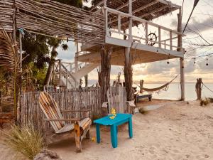 蓬塔露奇亚Bluemare EcoHotel Frente a la playa Ensendada的海滩上的房子,配有桌椅