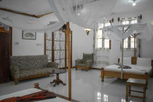 ChukwaniSULKHAN SERVICED APARTMENT的客厅配有天蓬床和椅子