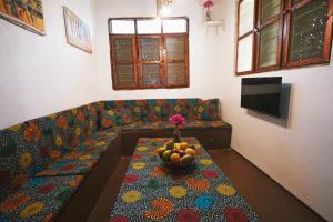 江比阿Cozy Lodge - Guesthouse的客厅配有一张长沙发及一碗水果