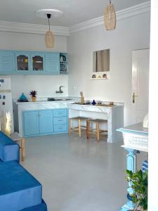 丹吉尔Dar Lahlou的厨房配有蓝色橱柜和桌子