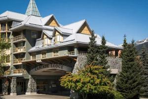 惠斯勒600 SQFT 1 Bed 1 Bath Mountain View Suite at Cascade Lodge in Whistler Village Sleeps 4的一座大型建筑,上面有一座塔