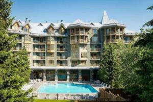 惠斯勒600 SQFT 1 Bed 1 Bath Mountain View Suite at Cascade Lodge in Whistler Village Sleeps 4的大型公寓大楼,设有大型游泳池