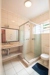 佩洛塔斯Pelotas Bier Hostel的一间带玻璃淋浴和卫生间的浴室