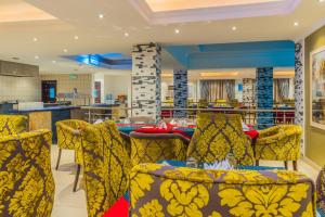 拉各斯拉各斯库拉莫水万豪Protea酒店的用餐室配有黄色椅子和桌子