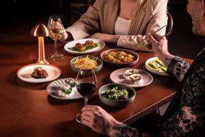 悉尼悉尼蓝塞瑞拉莫特酒店的一群坐在餐桌上的人,拿着盘子的食物