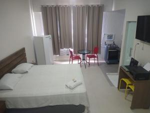 马瑙斯Temporada centro de Manaus 815的卧室配有一张床和一张桌子及椅子