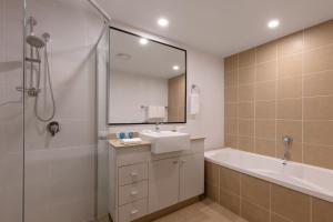 黄金海岸布罗德海滩美利通公寓式酒店的带浴缸、水槽和淋浴的浴室