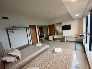 马瑙斯Hotel Tropical Executive Flat 918的酒店客房设有两张床和电视。