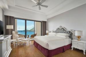 芽庄Nha Trang Marriott Resort & Spa, Hon Tre Island的一间白色的卧室,配有一张床,享有海景