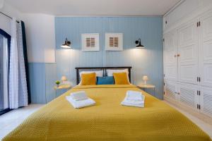 卡武埃鲁Casa Flor de Sal Apartment的一间卧室配有黄色的床和2条毛巾