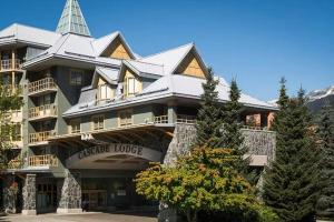 惠斯勒900 SQFT 2 Bed 2 Bath Renovated Suite at Cascade Lodge in Whistler Village Sleeps 6的一座大型建筑,上面有一座塔