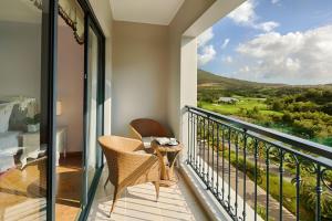 芽庄Nha Trang Marriott Resort & Spa, Hon Tre Island的设有一个配有桌椅并享有美景的阳台。