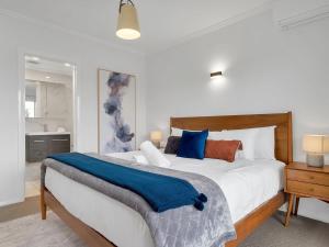 金德拜恩Alloura 2的一间卧室配有一张大床,上面有蓝色的毯子