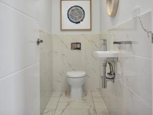 金德拜恩Alloura 2的白色的浴室设有卫生间和水槽。