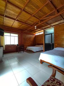 廷戈玛丽亚Cabañas Ecowasi的一间卧室设有两张床和木制天花板