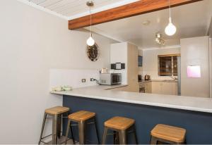 金德拜恩Erulisse的厨房配有木凳子和柜台