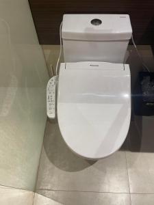 MaribagoReLuxe マリン Condo的浴室内的白色卫生间,配有遥控器