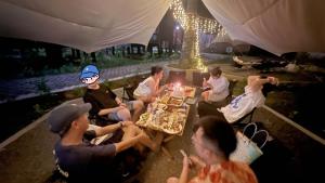 仙本那OPINE VILLAS/菠萝的海.度假别墅的一群坐在桌子旁吃食物的人