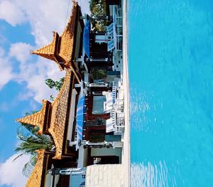 BanjarSoul Lodge Villa Lovina的一座带椅子的建筑和一座水中的游泳池