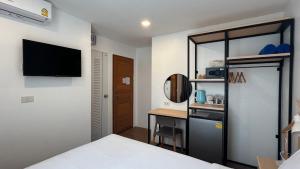 卡马拉海滩B3 HOUSE的一间卧室配有一张床、一张书桌和一台电视
