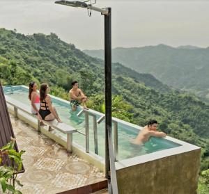 宿务Guillen Plantaciones Resort Farm的一群人在一座山地游泳池里