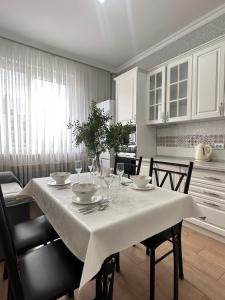 塔尔迪科尔Однокомнатные апартаменты на Экспо的餐桌上配有白色桌布