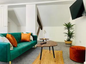 格洛斯特Penthouse - Contractors Professionals的客厅配有绿色沙发和桌子