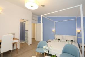 奇维塔韦基亚乡村别墅住宿加早餐旅馆的一间卧室配有一张床和两张蓝色椅子