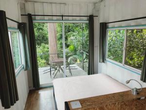 新古毛Sarang by the brook的一间卧室设有一张床和一个大窗户