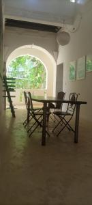 拉穆Jamala Guesthouse的配有大窗户的客房内的桌椅