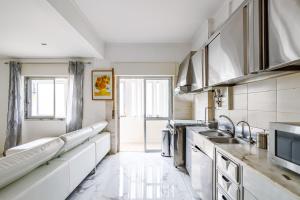 阿莫拉Moreira的一间厨房,配有白色家电和大窗户