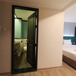 彭世洛彭世洛五月花大酒店的通往卧室的开放式门,卧室配有一张床和卫生间