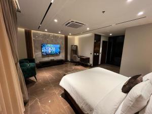 伊斯兰堡Jacaranda Heights的配有一张床和一台平面电视的酒店客房