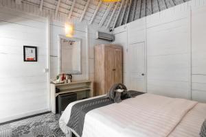 库塔轻松冲浪营地的一间拥有白色墙壁的卧室和一张位于客房内的床