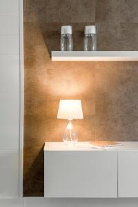 马德里Chalet independiente de diseño con Patio Privado的白色桌子上的一盏灯,墙上是棕色的墙