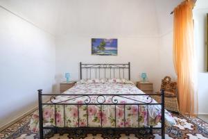 莫诺波利La casa di pietra location Rosy的一间卧室配有一张带花卉床罩的床