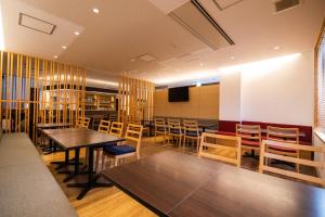 山口Business Hotel Ueno的一间带桌椅和电视的用餐室