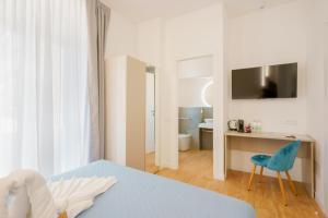 卡利亚里Aqua Comfort Rooms - Eja Sardinia的一间卧室配有一张床、一张桌子和一把椅子