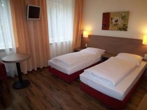汉堡马瑞恩塔尔伽尼酒店的酒店客房设有两张床和一张桌子。