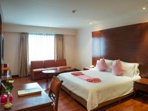 曼谷帕拉左酒店的酒店客房设有一张大床和一张沙发。