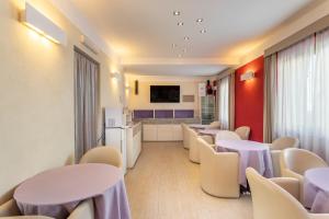 维拉西米乌斯贝尔维尔酒店的一间设有桌椅的等候室和一间厨房