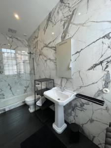 阿拉斯Maison Manotte d’Artois的浴室配有白色水槽和大理石墙