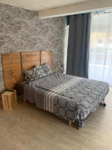 Châtillon-Saint-JeanSuite parentale 50m2的一间卧室设有一张床和砖墙