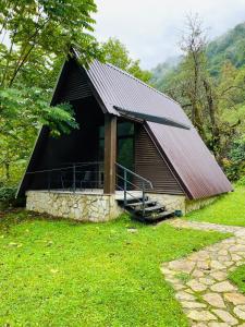 科布列季Mtirala National Park hotel ORBEZA的草场上带黑色屋顶的小小屋