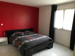 HauteriveChambre chez l’habitant en pleine campagne !的一间卧室设有一张床和红色的墙壁