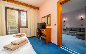 奥斯特拉维采翁德拉兹贝思柯德酒店的一间卧室配有一张床和一张书桌及电视