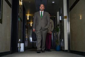 阿布扎比AG酒店的穿着西装,带绿色领带的人沿着走廊走