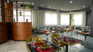 卡萨布兰卡Fourteen Hotel Ain Sebaa的一间在房间内配有桌椅的餐厅