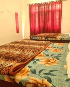 斯利那加Hotel City Way, Srinagar的配有图案地毯的客房内的两张床