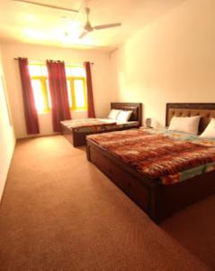 斯利那加Hotel City Way, Srinagar的酒店客房带两张床和两个窗户